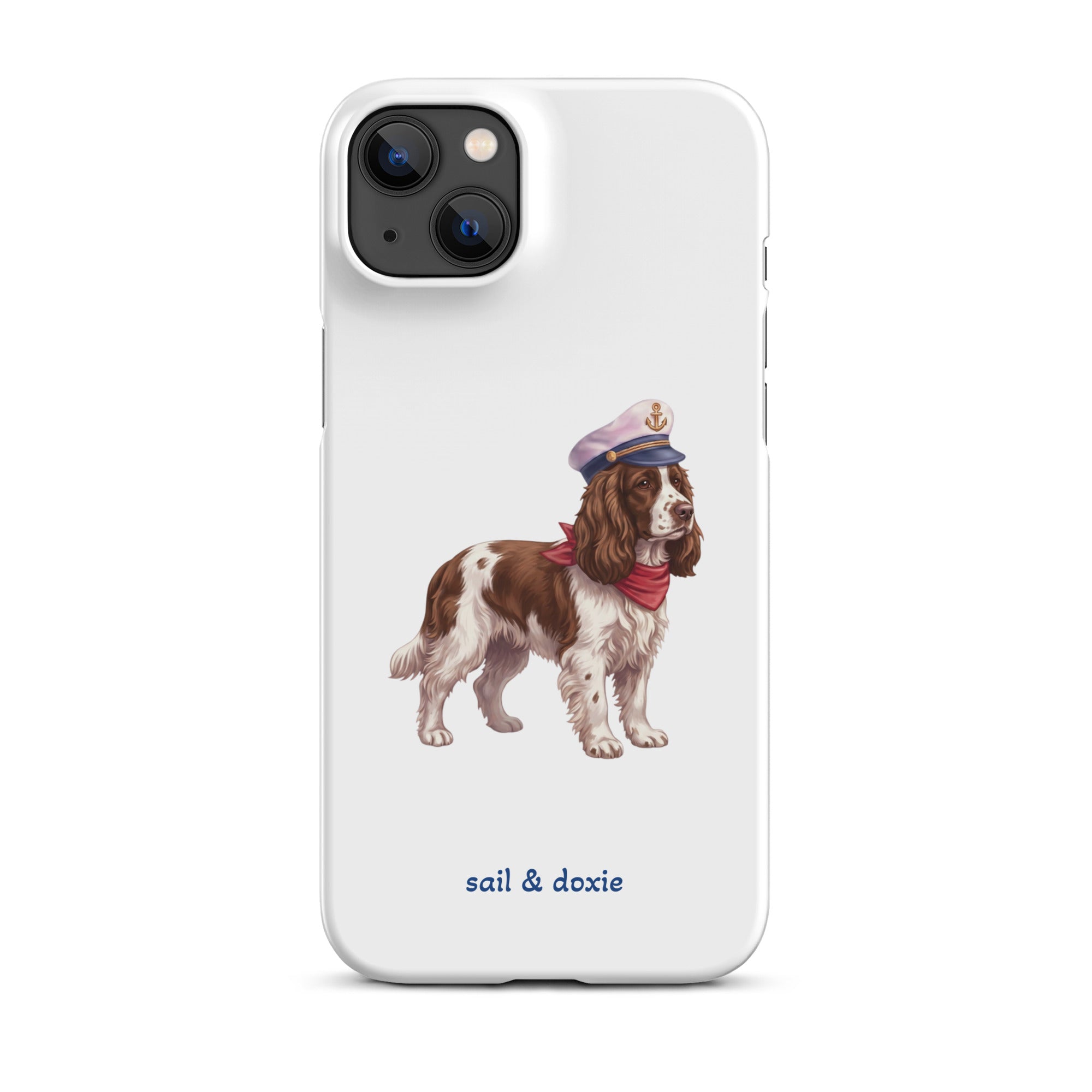 A white phone case featuring an illustration of a brown and white springer spaniel wearing a navy blue captain's hat and red neck scarf, with the text 'sail & doxie' printed in blue below. 