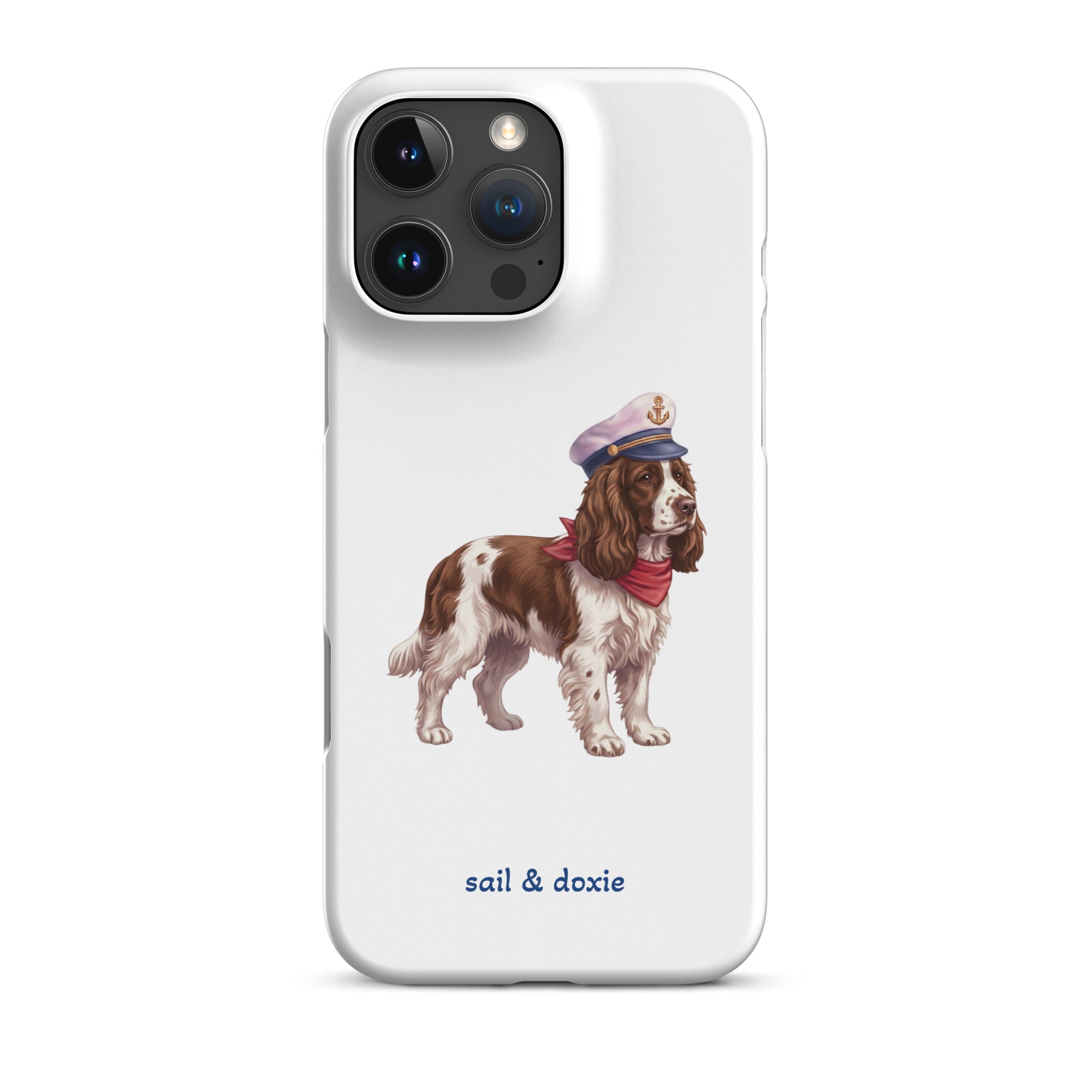 A white phone case featuring an illustration of a brown and white springer spaniel wearing a navy blue captain's hat and red neck scarf, with the text 'sail & doxie' printed in blue below. 