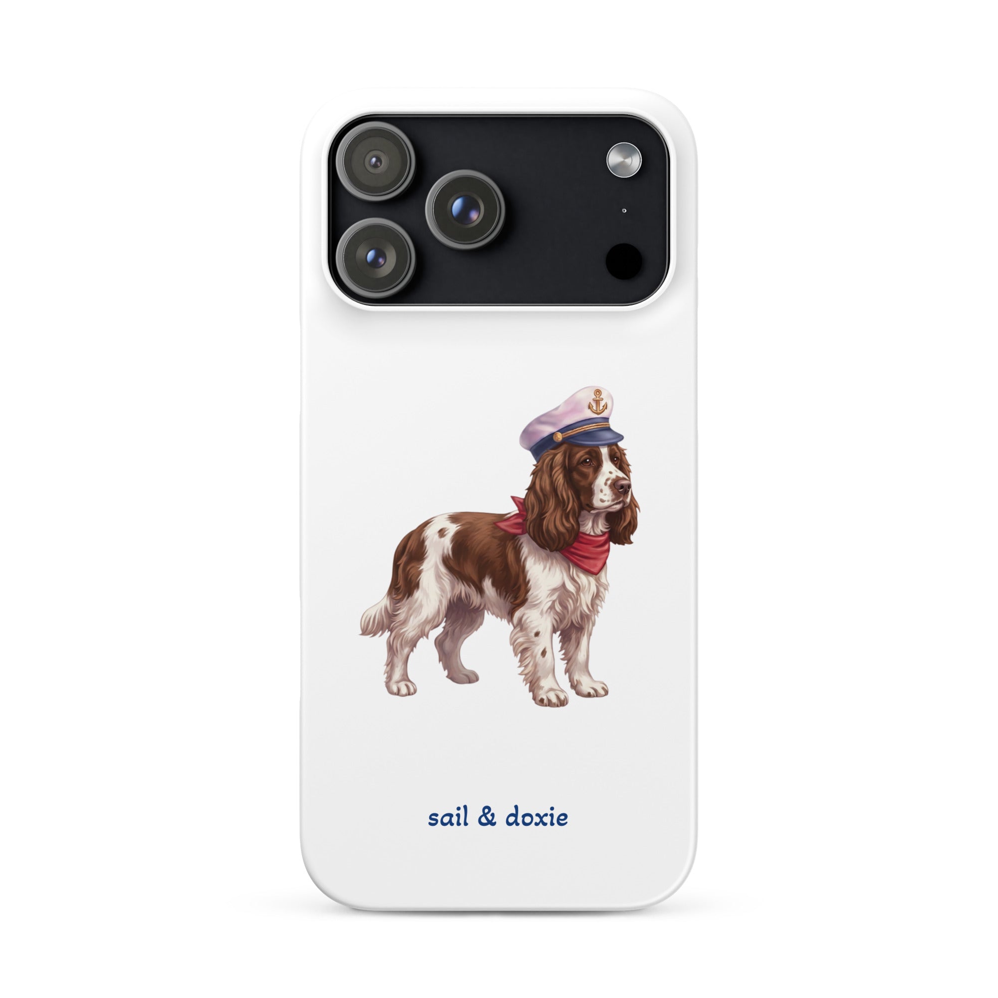 A white phone case featuring an illustration of a brown and white springer spaniel wearing a navy blue captain's hat and red neck scarf, with the text 'sail & doxie' printed in blue below. 